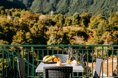 a table with a bowl of fruit on a balcony at Olinda's Place by Amazing Madeira in Boaventura
