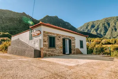 a small building with mountains in the background at Olinda's Place by Amazing Madeira in Boaventura