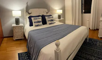 a bedroom with a large bed with blue pillows at Madalena Sunset by Homie in Madalena do Mar