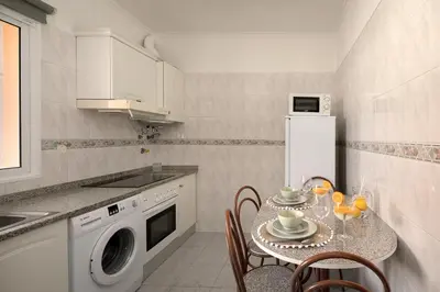 a kitchen with a table with chairs and a microwave at Madalena Sunset by Homie in Madalena do Mar