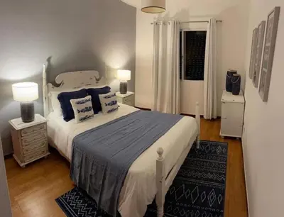 a bedroom with a large bed with blue pillows at Madalena Sunset by Homie in Madalena do Mar