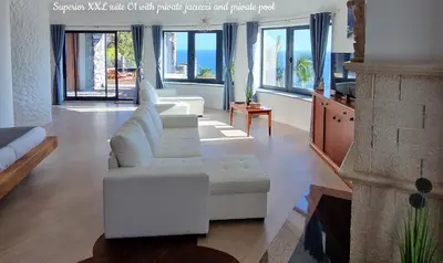 a living room with a white couch and a fireplace at Castelo do Mar, Madeira in Tábua