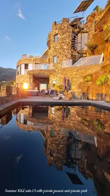 a reflection of a building in a body of water at Castelo do Mar, Madeira in Tábua