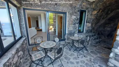 a patio with tables and chairs on a stone wall at Castelo do Mar, Madeira in Tábua