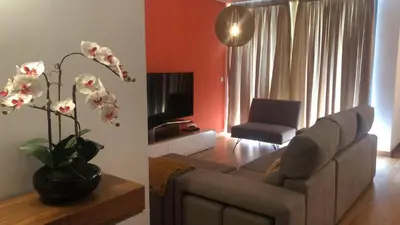 a living room with a couch and a vase with flowers at Peaceful Apartment in Funchal