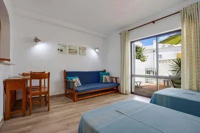 a bedroom with a bed and a chair and a window at Luz Studio in Luz