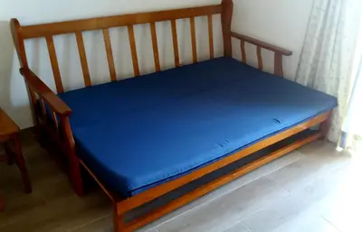 a wooden bed with a blue sheet on it at Luz Studio in Luz