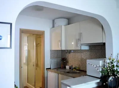 a kitchen with white cabinets and a sink at Luz Studio in Luz