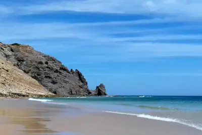 a beach with a cliff and the ocean at Luz Studio in Luz