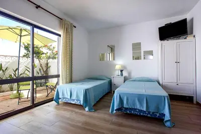 a bedroom with two beds and a large window at Luz Studio in Luz