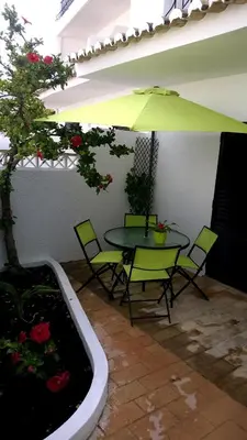 a patio with a table and chairs and an umbrella at Luz Studio in Luz