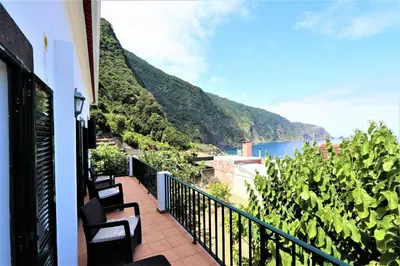 a balcony with a view of the ocean and mountains at Casa do Seixal in Seixal