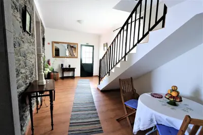 a living room with a table and stairs at Casa do Seixal in Seixal