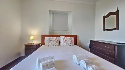 a bedroom with a large white bed with two night stands at Casa do Seixal in Seixal