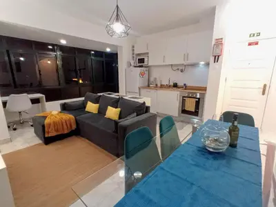 a living room and kitchen with a couch and a table at Panoramic View Apartment in Funchal