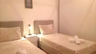 a small bedroom with two beds and a lamp at Panoramic View Apartment in Funchal
