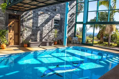 a swimming pool in front of a house at Vila Afonso in Estreito de Câmara de Lobos