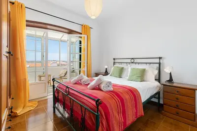 a bedroom with a large bed and a balcony at Sweet Home Sagres in Sagres