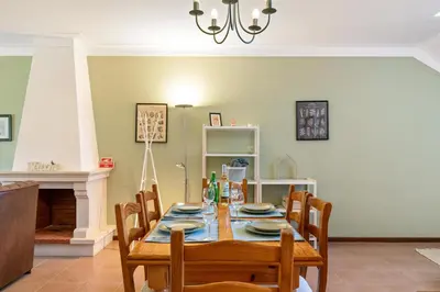 a dining room with a table with chairs and a chandelier at Sweet Home Sagres in Sagres