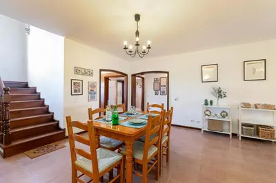 a dining room with a wooden table and chairs at Sweet Home Sagres in Sagres