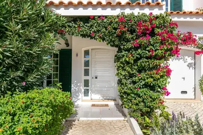 a white door with flowers on it in front of a house at Sweet Home Sagres in Sagres