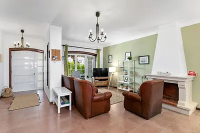 a living room with leather chairs and a fireplace at Sweet Home Sagres in Sagres