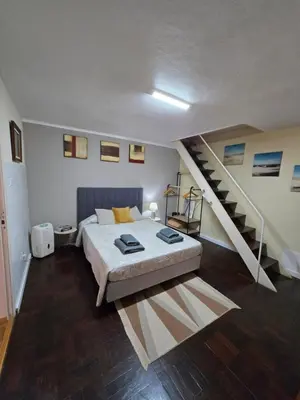 a bedroom with a bed and a staircase at CASA RIBEIRINHO No Coração da Natureza in Ponta do Pargo