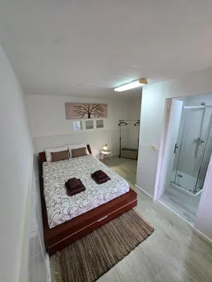 a bedroom with a bed with two pillows on it at CASA RIBEIRINHO No Coração da Natureza in Ponta do Pargo