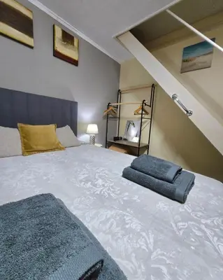 a bedroom with a large bed with two pillows on it at CASA RIBEIRINHO No Coração da Natureza in Ponta do Pargo