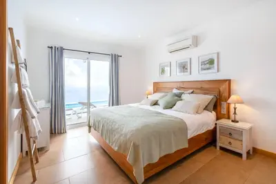 a swimming pool with a view of the ocean at Villa Acacia in Arco da Calheta