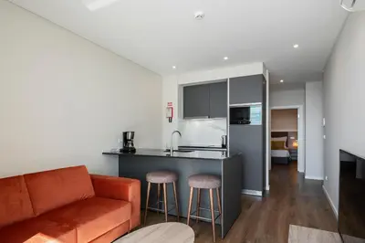 a kitchen and living room with a couch and a counter at Monumental Plaza by Petit Hotels in Funchal