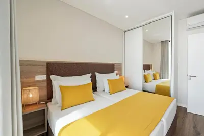 a hotel room with two beds with yellow pillows at Monumental Plaza by Petit Hotels in Funchal