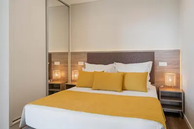 a bedroom with a large bed with yellow pillows at Monumental Plaza by Petit Hotels in Funchal