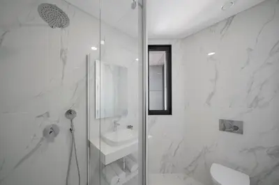 a white bathroom with a shower and a sink at Monumental Plaza by Petit Hotels in Funchal
