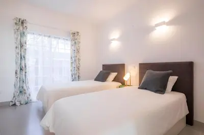 two beds in a room with a window at Beautiful Seaview 2 Bedroom Apartment in Luz