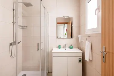 a white bathroom with a shower and a sink at Atlantic Studios #02 in Funchal