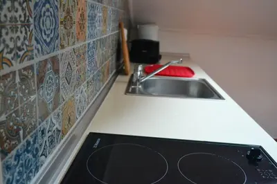 a kitchen counter with a sink and a stove at Lazy Lizard Studio in Seixal