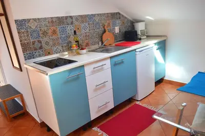 a kitchen with blue and white cabinets and a sink at Lazy Lizard Studio in Seixal
