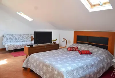a bedroom with a bed and a flat screen tv at Lazy Lizard Studio in Seixal