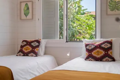 two beds in a room with a window at Casa da Rocha de Baixo by An Island Apart in Santana