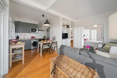a living room with a gray couch and a kitchen at Casa da Rocha de Baixo by An Island Apart in Santana