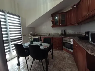a large kitchen with wooden cabinets and a table at Charm Penthouse Ocean View in Calheta