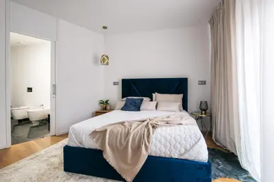 a bedroom with a blue and white bed and a bathroom at Funchal BEAUTIFUL vista mar in Funchal
