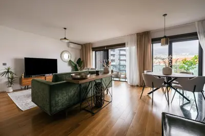 a living room with a green couch and a television at Funchal BEAUTIFUL vista mar in Funchal