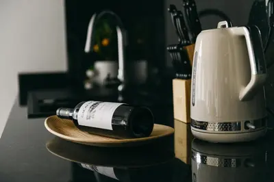 a bottle of wine on a plate next to a coffee maker at Funchal BEAUTIFUL vista mar in Funchal