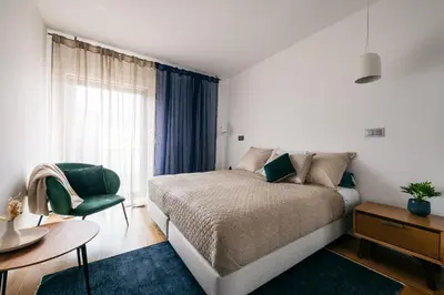 a bedroom with a bed and a chair and a window at Funchal BEAUTIFUL vista mar in Funchal