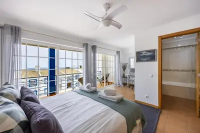 a bedroom with a bed and a large window at CoolHouses Luz, Lovely 3 Bed Townhouse & sea views, Casa Baía da Vida in Luz