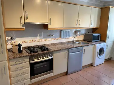 a kitchen with a stove and a sink and a dishwasher at CoolHouses Luz, Lovely 3 Bed Townhouse & sea views, Casa Baía da Vida in Luz