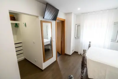 a bedroom with a bed and a window and a mirror at Madeira Bird House - House in the Mountains With Garden in São Vicente