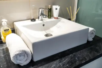 a white sink in a bathroom with towels at Madeira Bird House - House in the Mountains With Garden in São Vicente